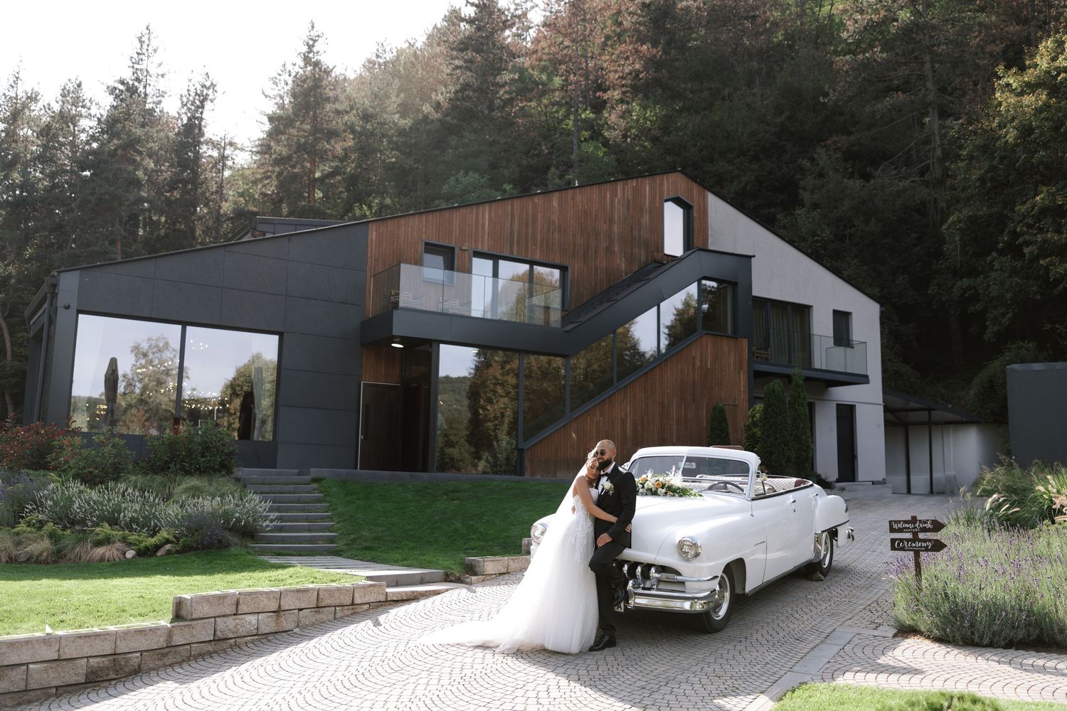 Modern architectural homes with dark exterior panels nestled among trees on a hillside property.