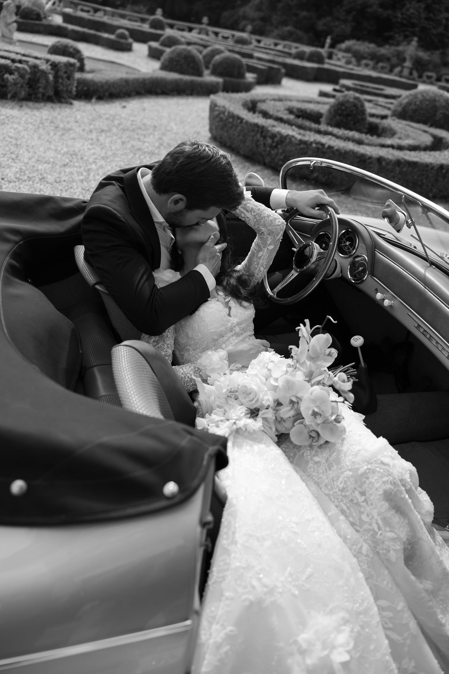 A sequence of black and white wedding photos showing a couple in a convertible car with a flowing white dress.
