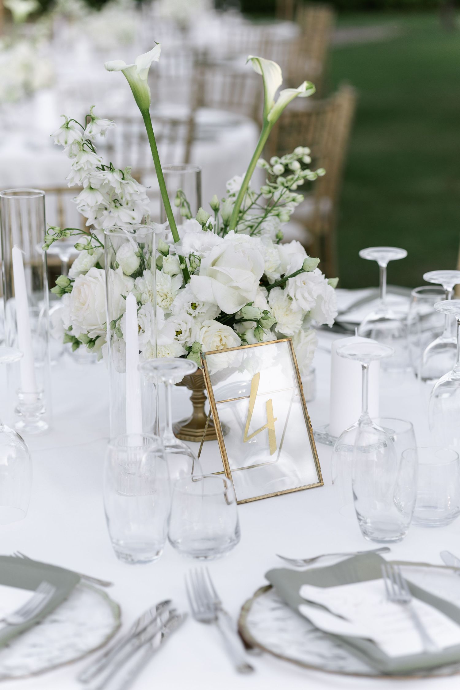 Elegant white wedding table settings with delicate floral centerpieces and crystal glassware create a romantic atmosphere.