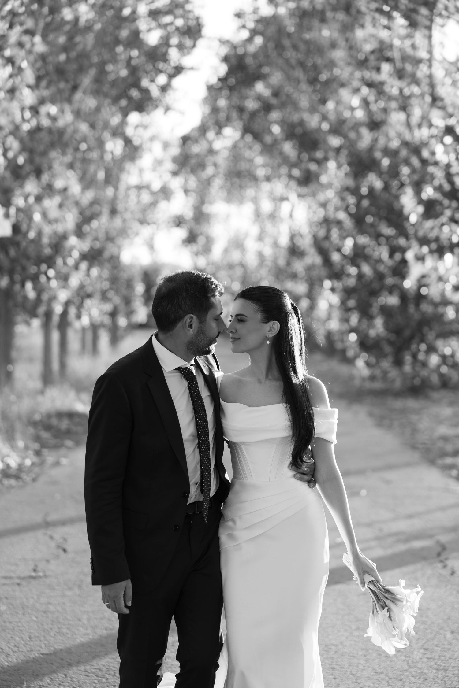 A romantic black and white wedding photo series showing a couple sharing intimate moments in an outdoor setting.