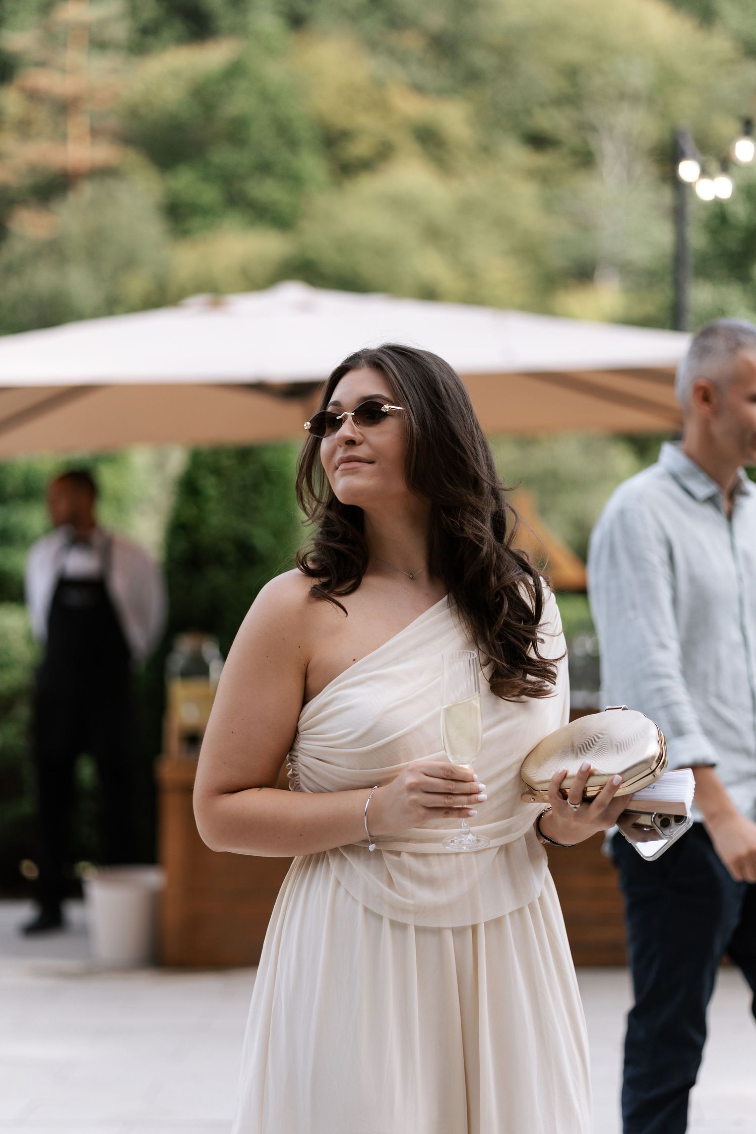 A person in a flowing white dress dances and spins joyfully at an outdoor event.