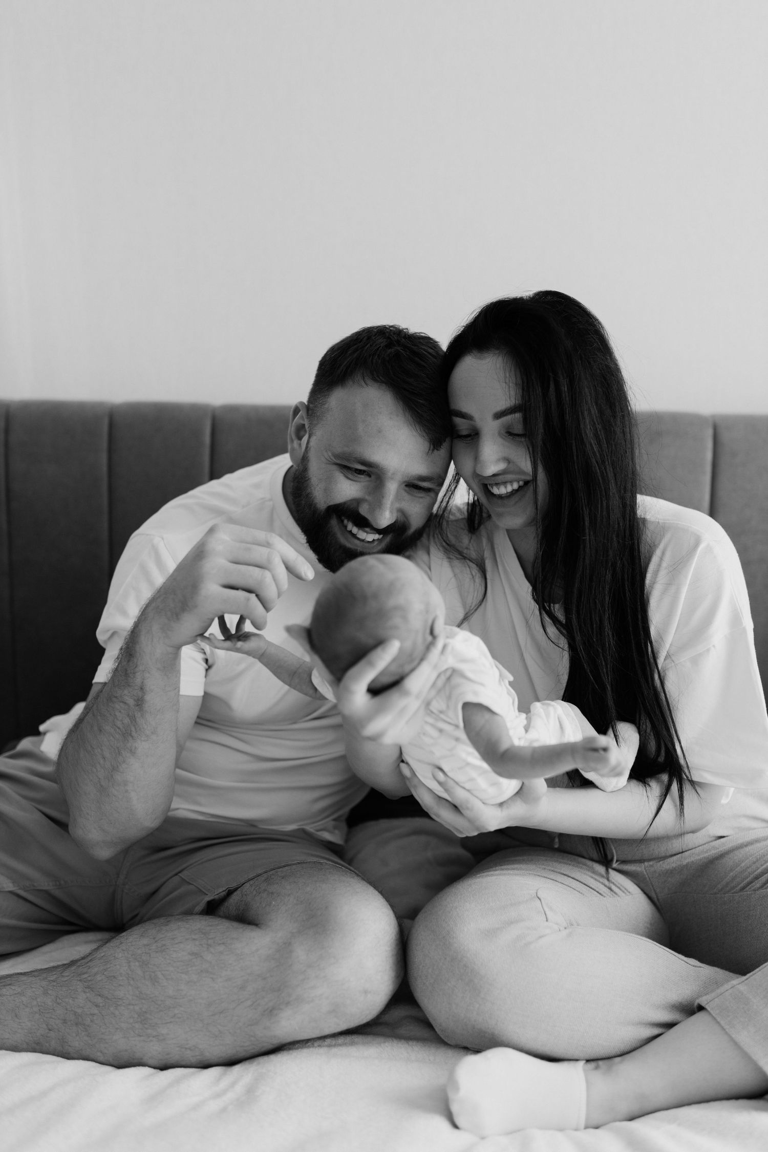 A black and white portrait of a happy family sharing joyful moments with their newborn.