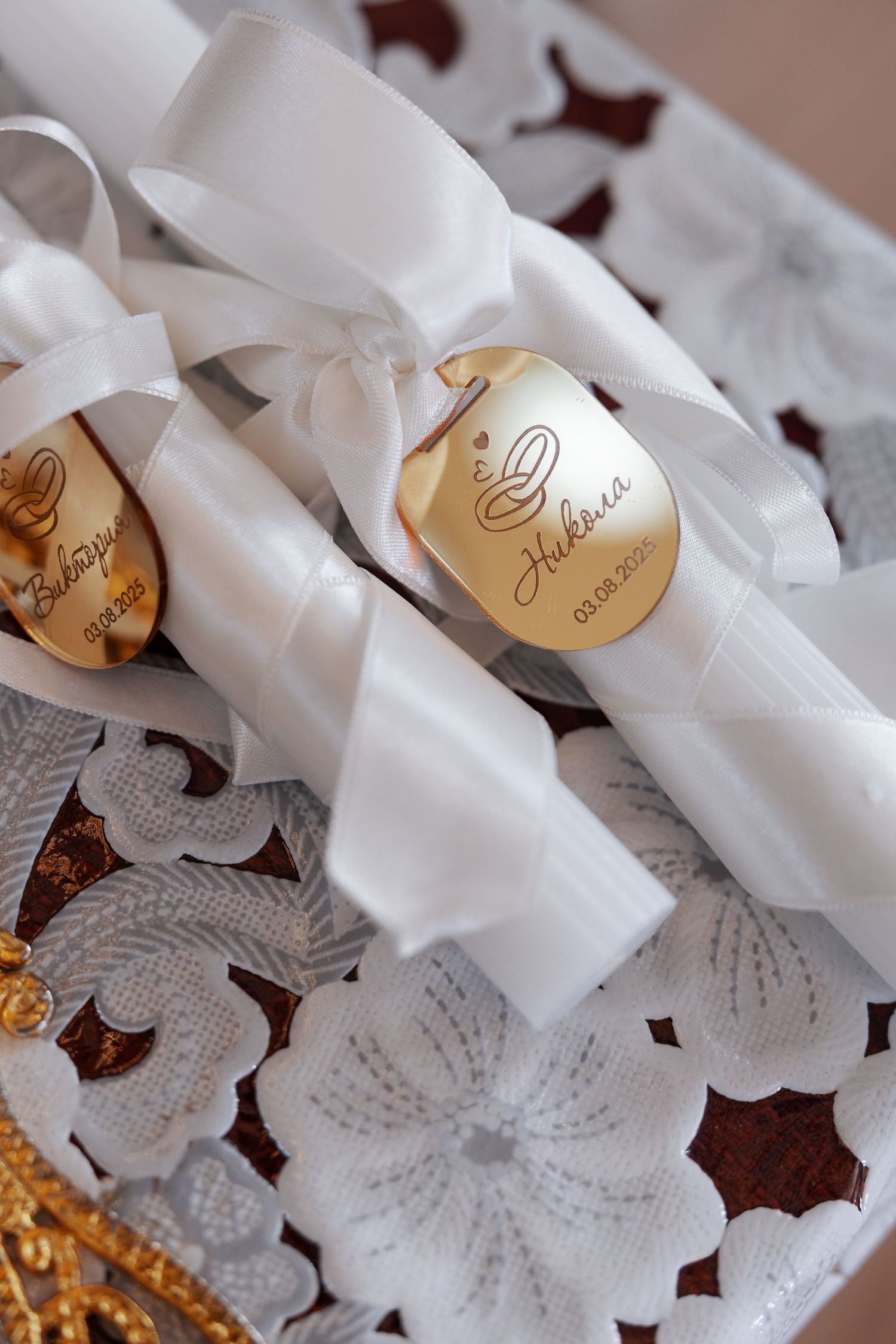White rolled paper scrolls tied with ribbons arranged in rows with gold accents and dark decorative elements.