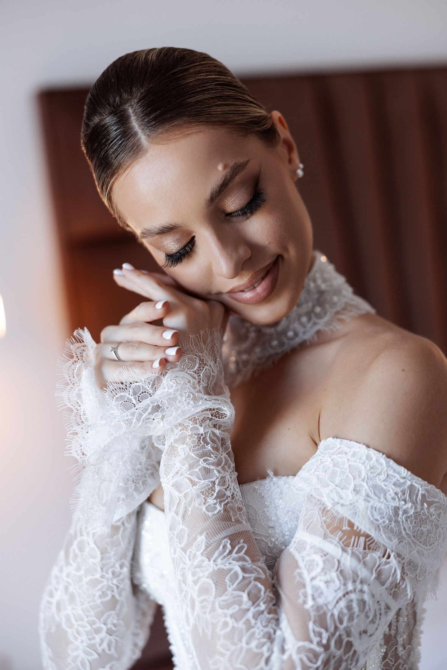 Close-up details of a luxurious lace wedding dress with long sleeves and intricate embroidery.
