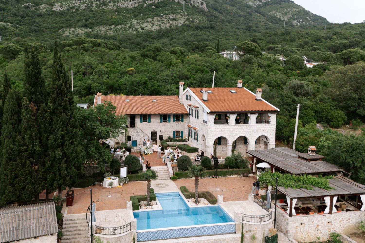 Scenic mountain resort property with swimming pool and terrace overlooking lush green Mediterranean landscape.