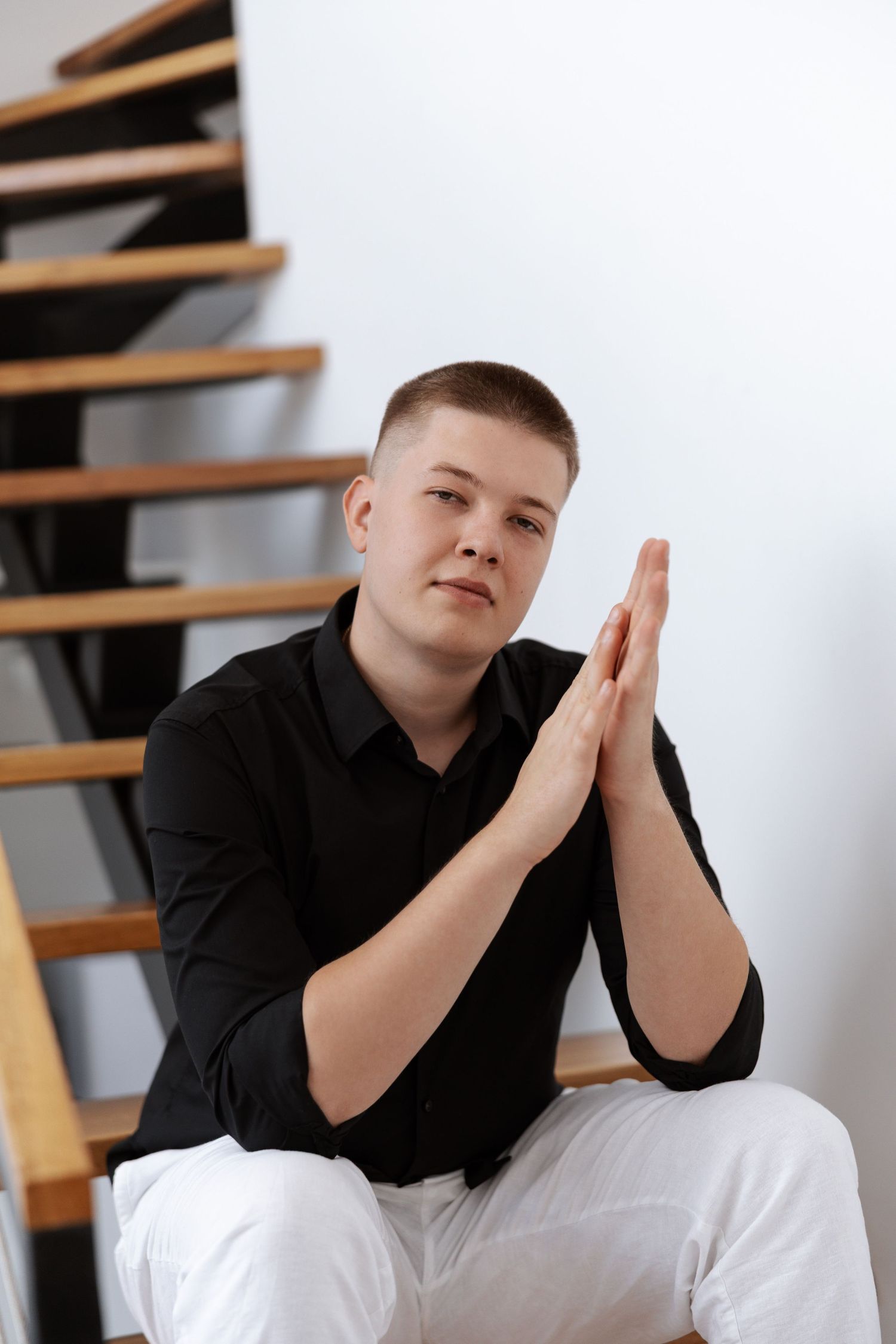 A series of artistic black and white portraits showing someone in a black shirt and white pants against a light background.