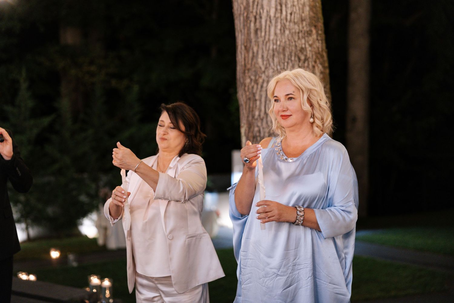 Guests enjoying conversation during an outdoor evening wedding reception.