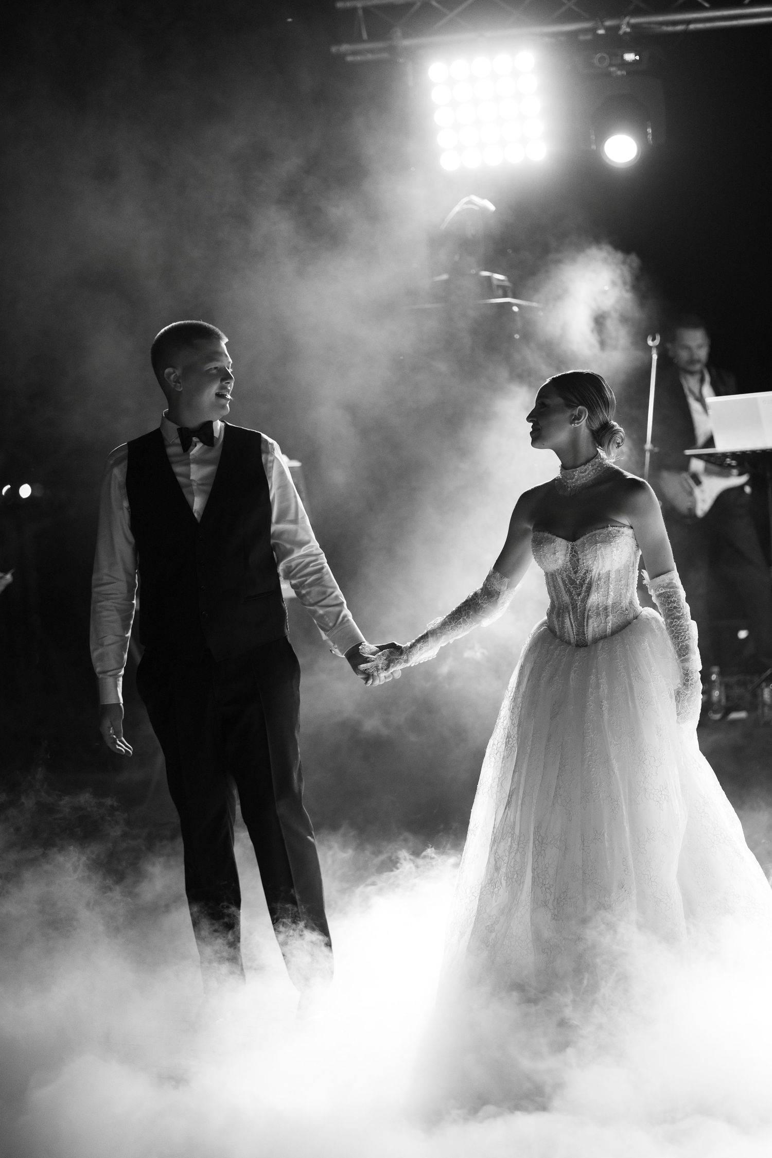 Dramatic dance floor scene with fog effects and theatrical lighting at wedding reception.