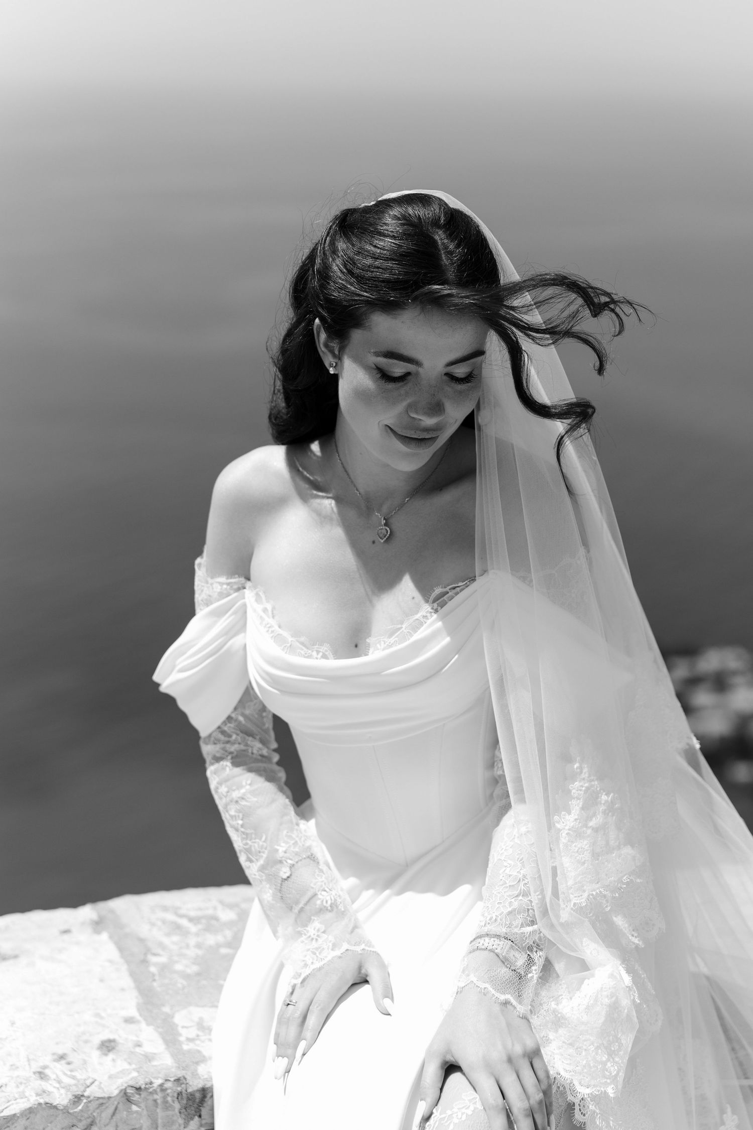 A series of black and white wedding photos showing a bride in an elegant white gown with a flowing veil.