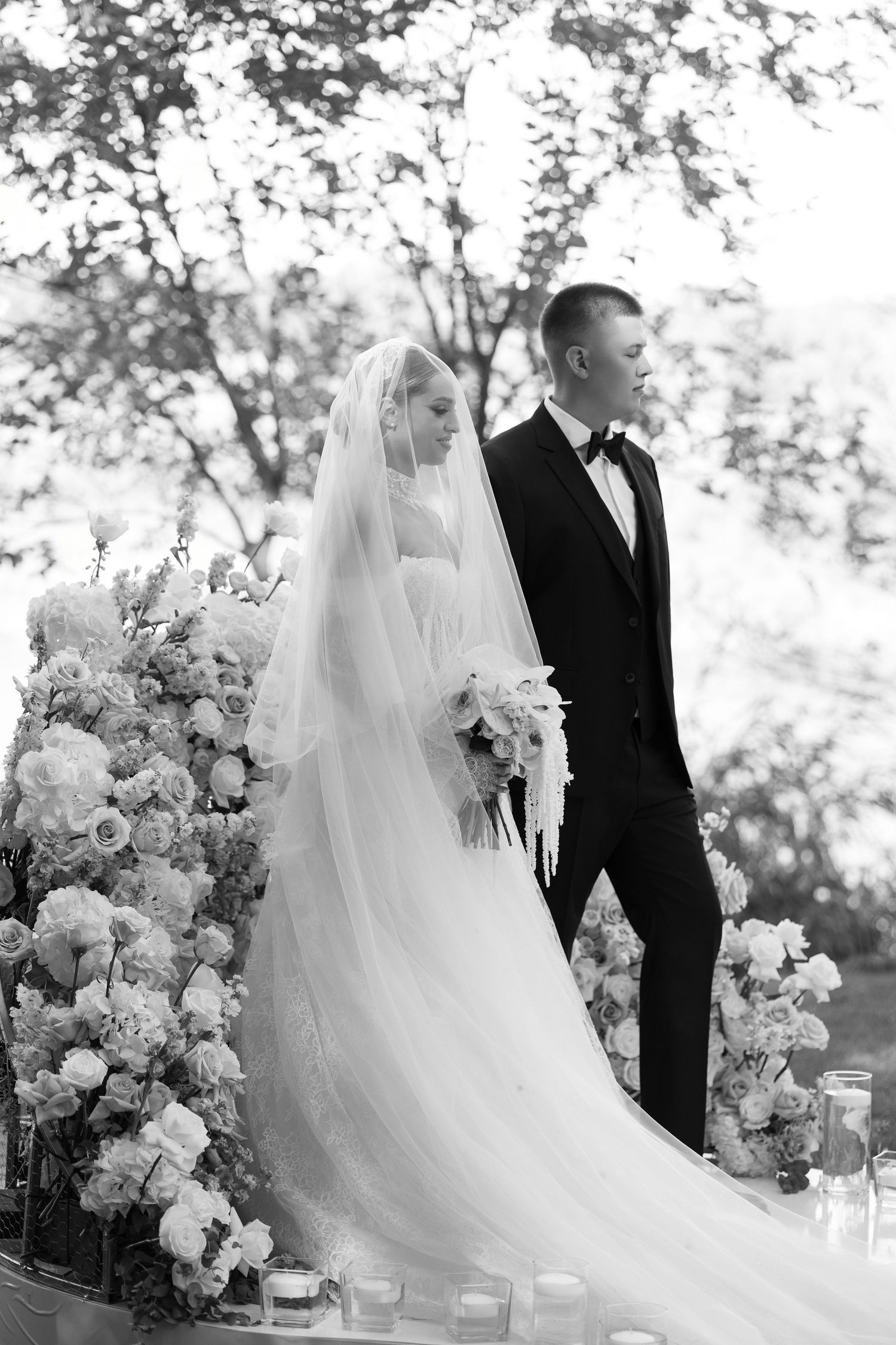 Black and white wedding ceremony photos with dramatic floral arrangements framing the couple.