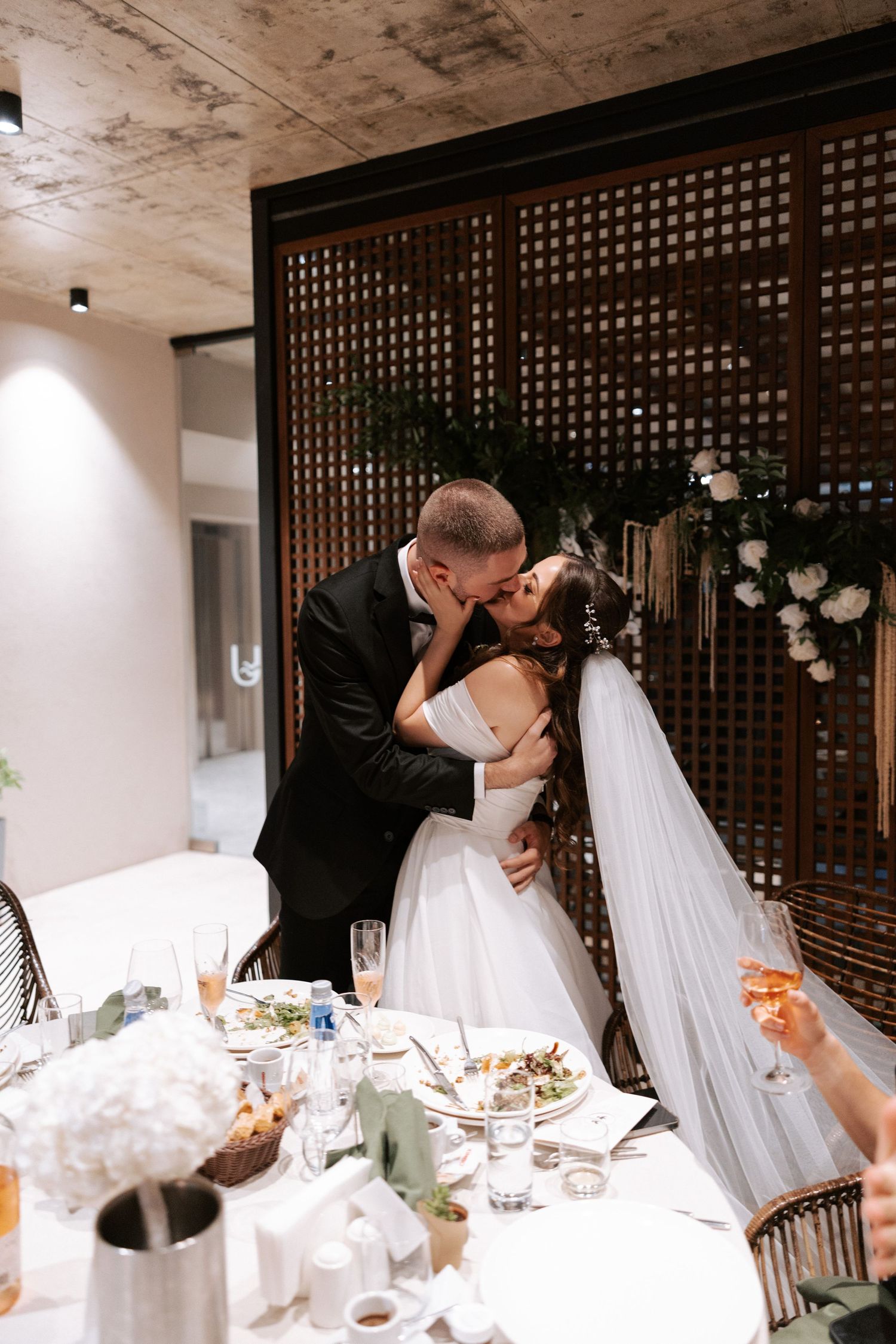 Romantic wedding couple sharing an intimate moment at their reception dinner table.