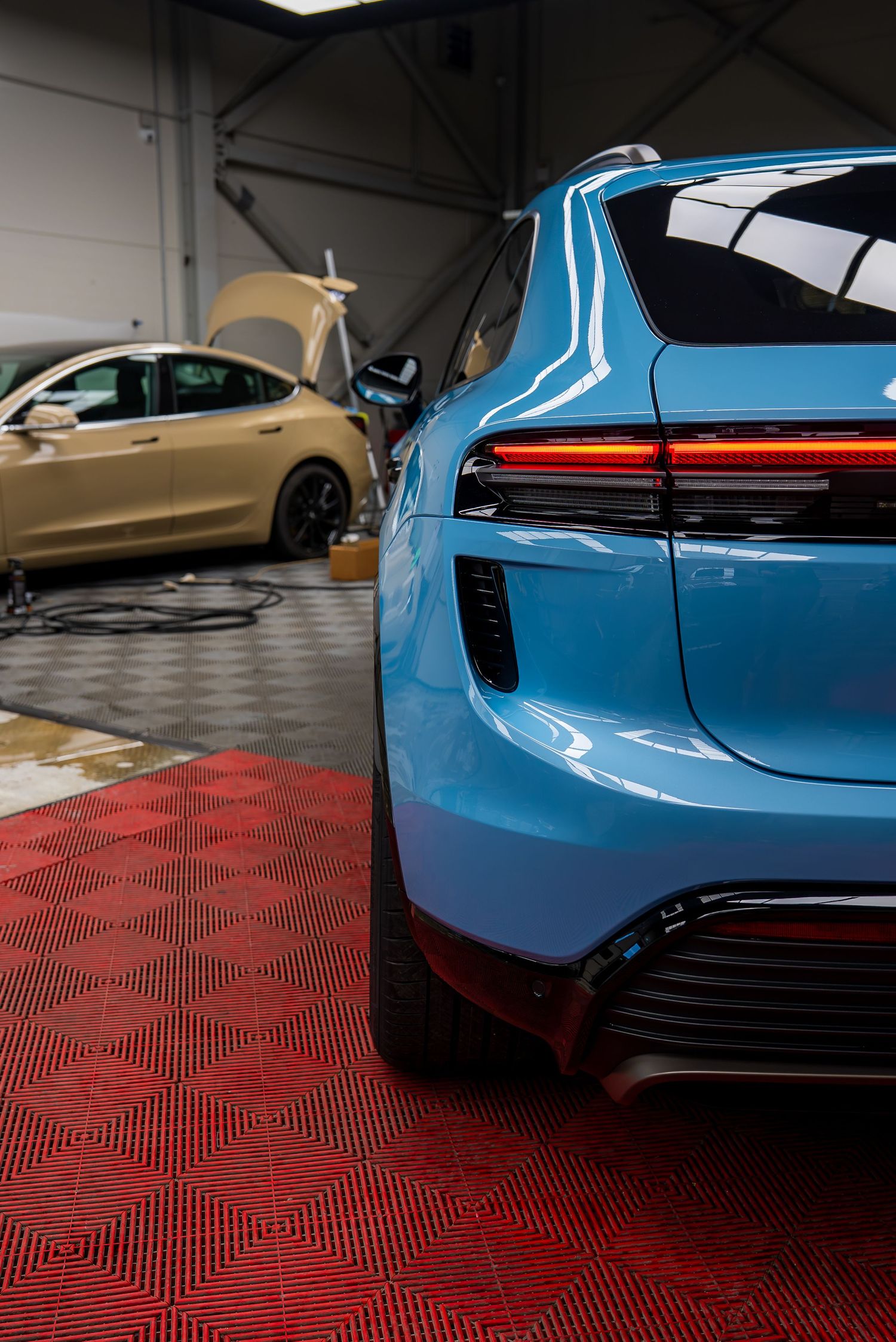 Rear view details of luxury sports cars in blue and gold showcasing distinctive taillights.