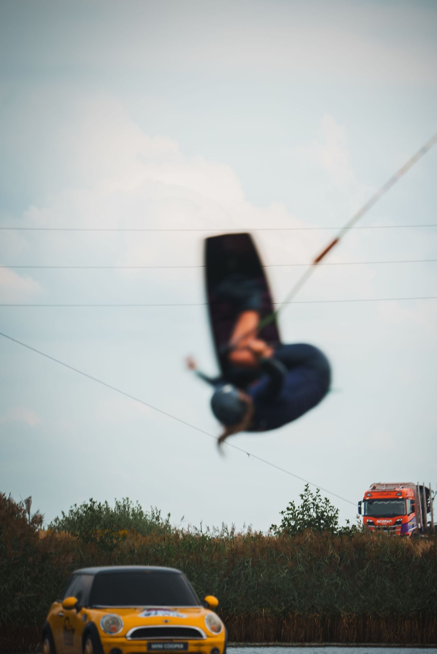 Motion blur sequence of objects flying through air with yellow car visible in background.