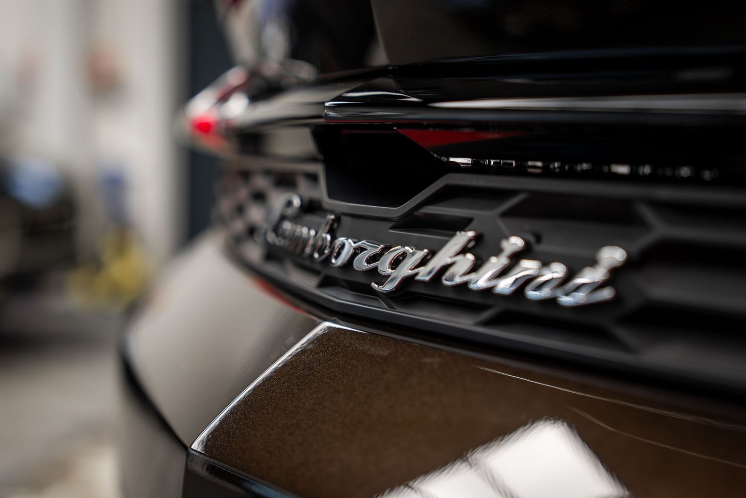 Glossy black Bentley badge detail on exterior panel showing premium branding.