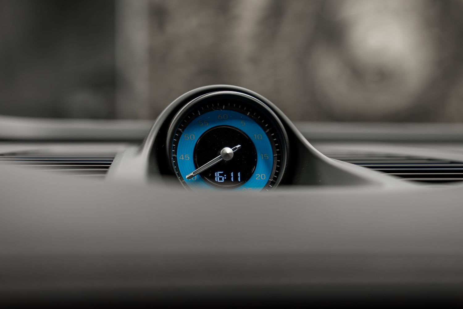 Blue-illuminated digital gauge cluster showing speed display in modern vehicle interior.