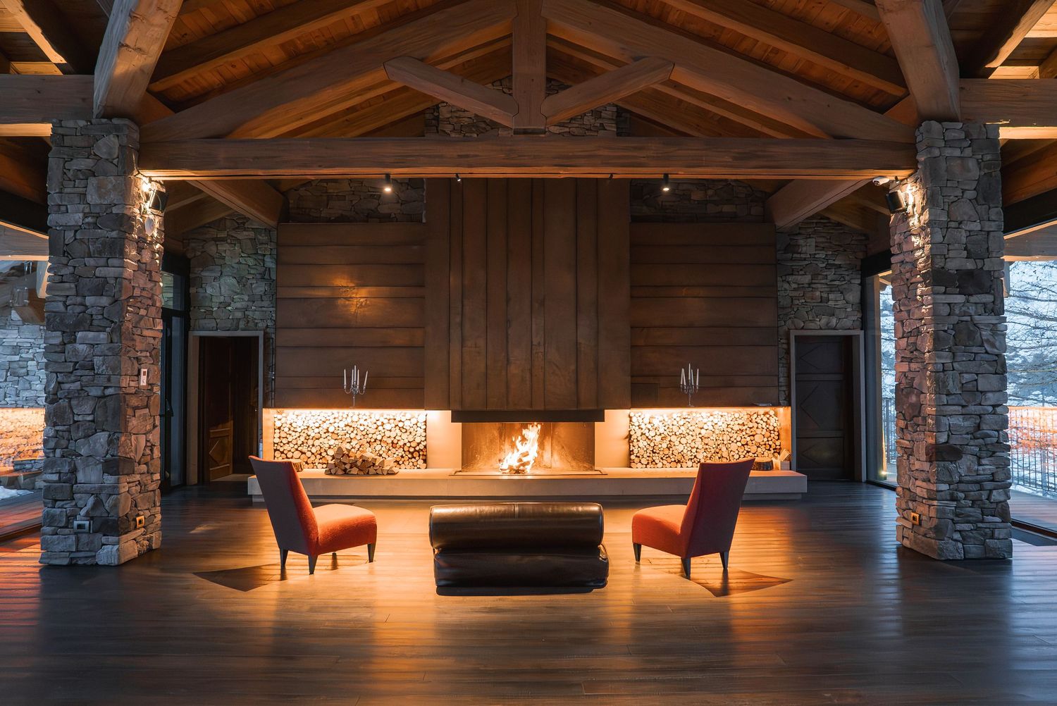 Luxurious mountain lodge interior with stone pillars and ambient lighting.
