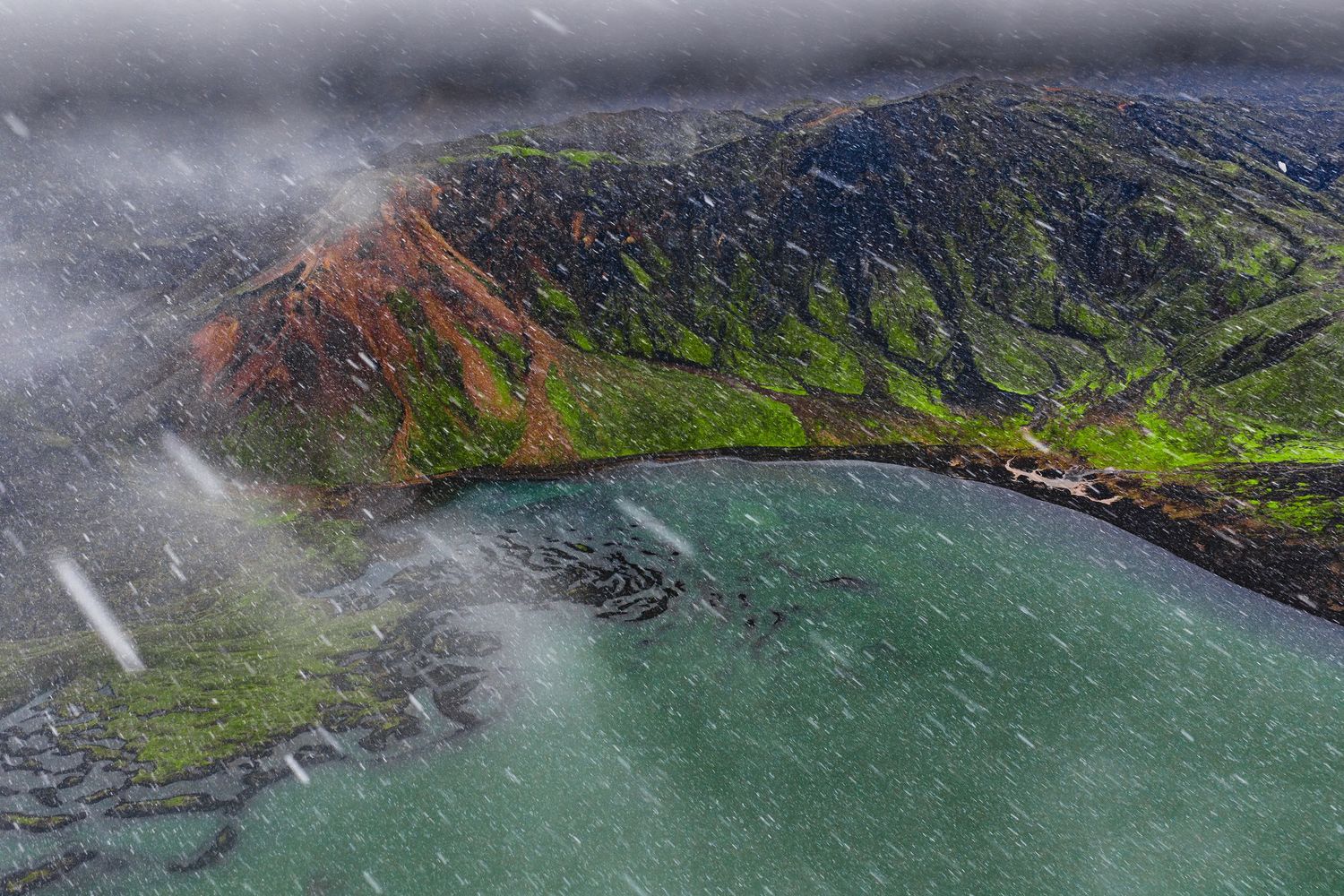 Aerial panoramic view of rugged coastal cliffs and turquoise waters along a dramatic volcanic shoreline.