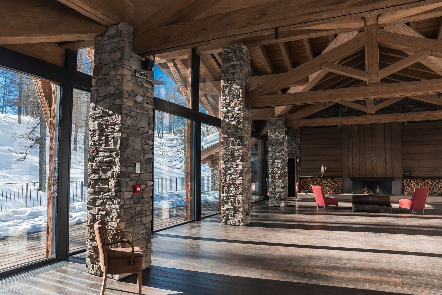 Rustic mountain lodge interior with exposed wooden beams and stone pillars.