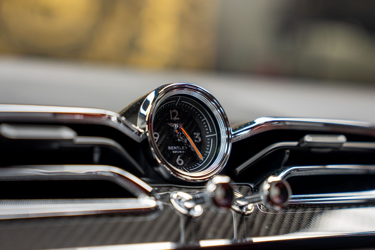 Dashboard gauges and controls of a high-end sports car with chrome accents.
