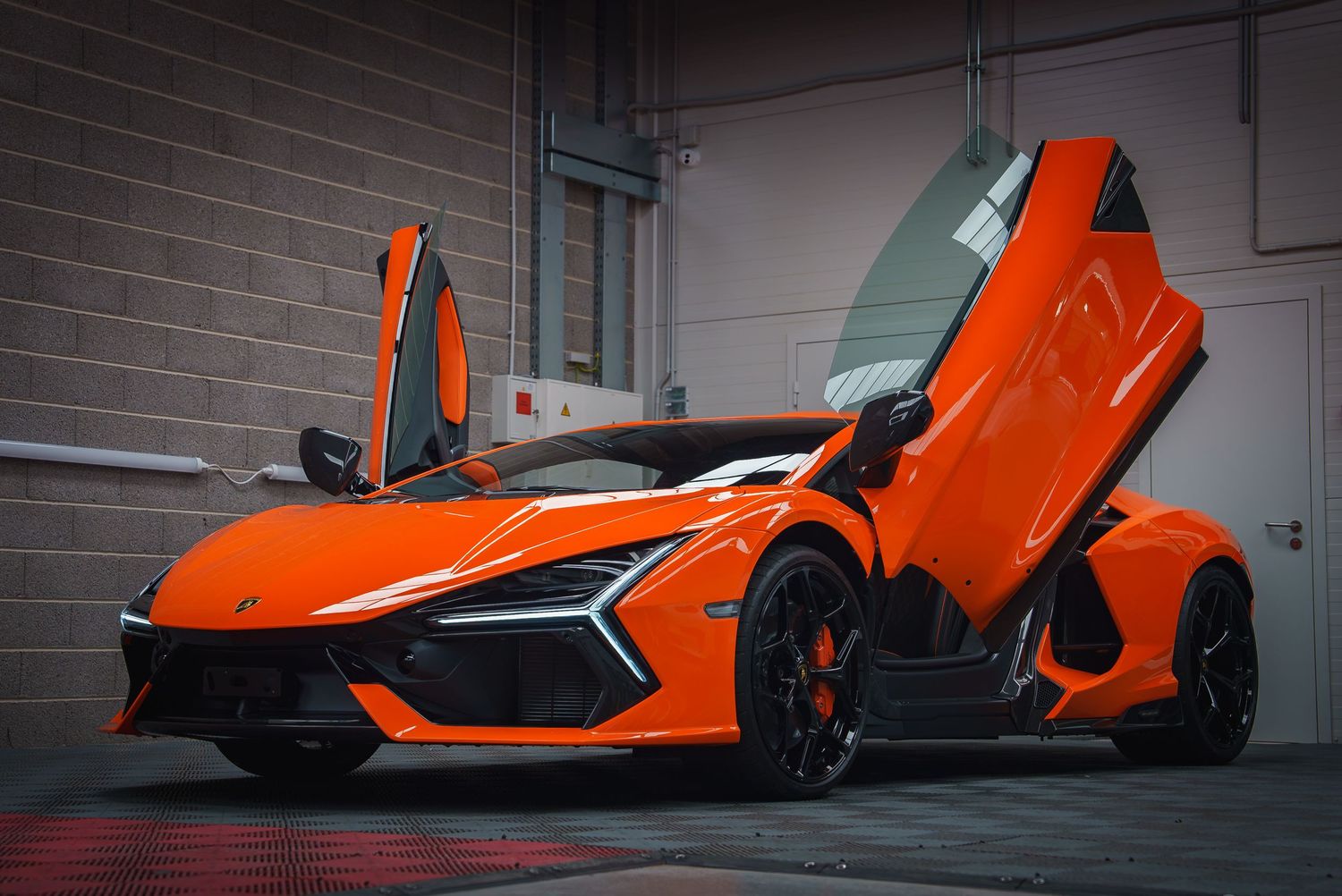 Orange McLaren supercar with scissor doors open displaying its dramatic design.
