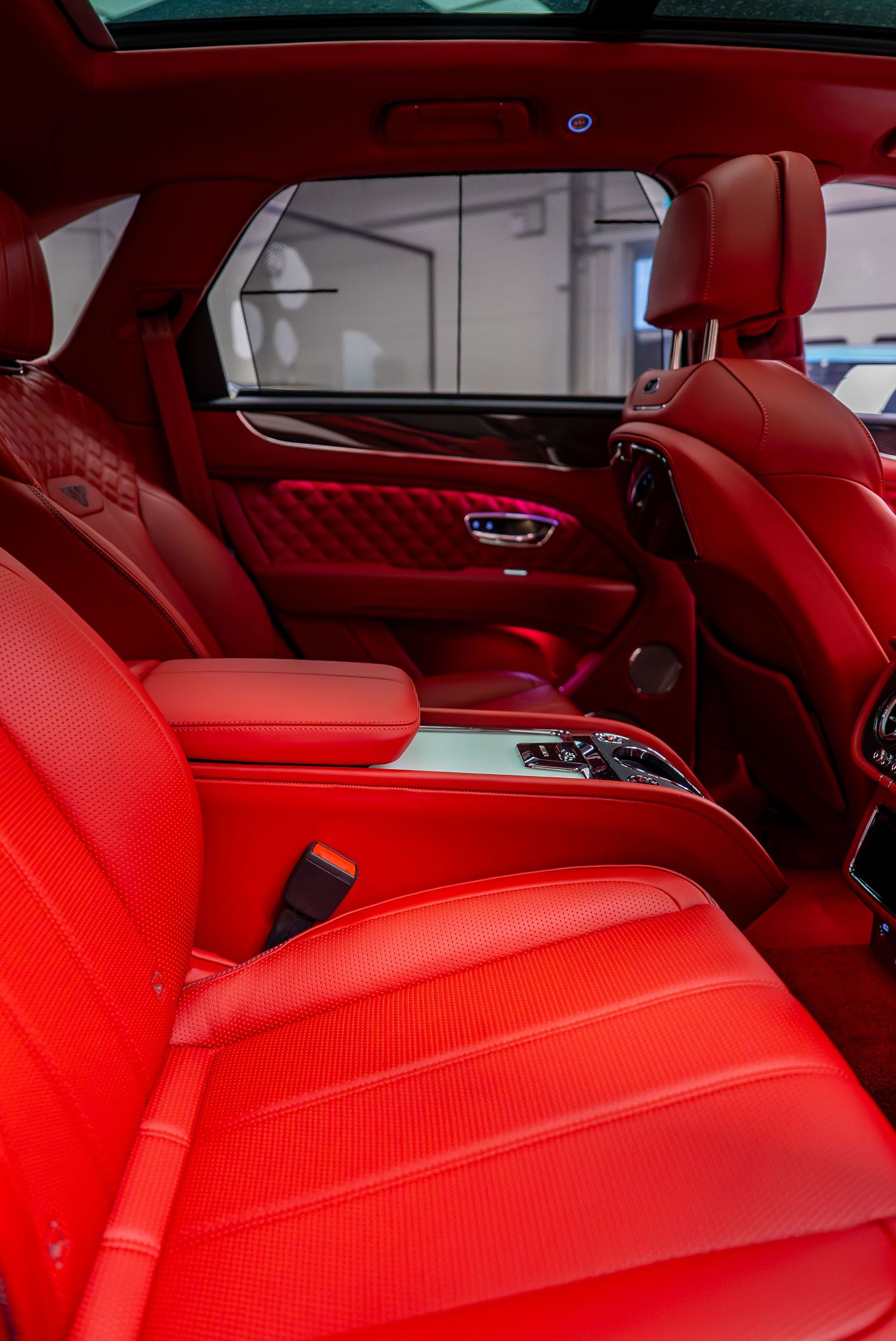 Luxurious red leather interior of a high-end car with quilted seats and modern center console.