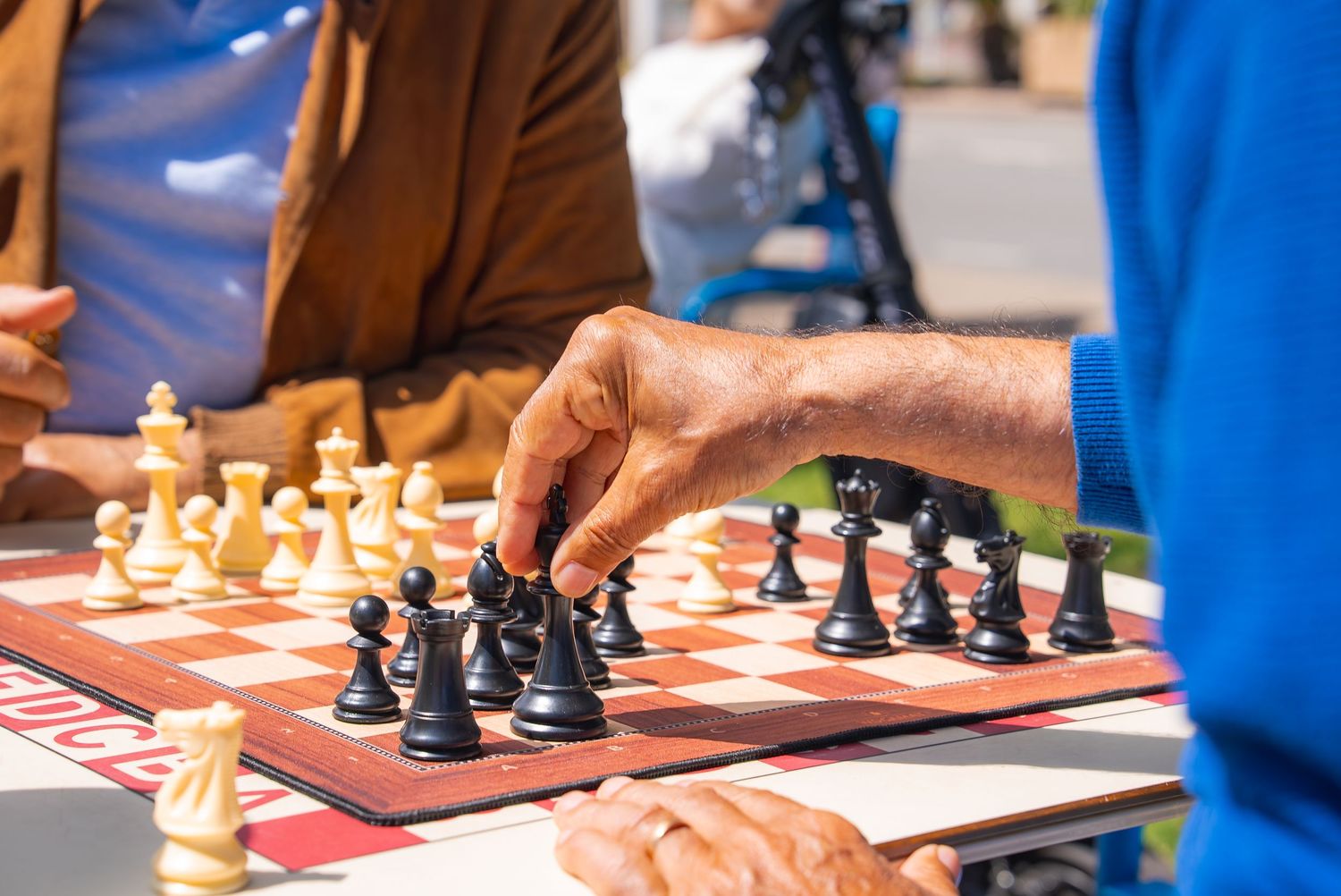 Close-up of chess pieces on multiple boards during a tournament or game session.