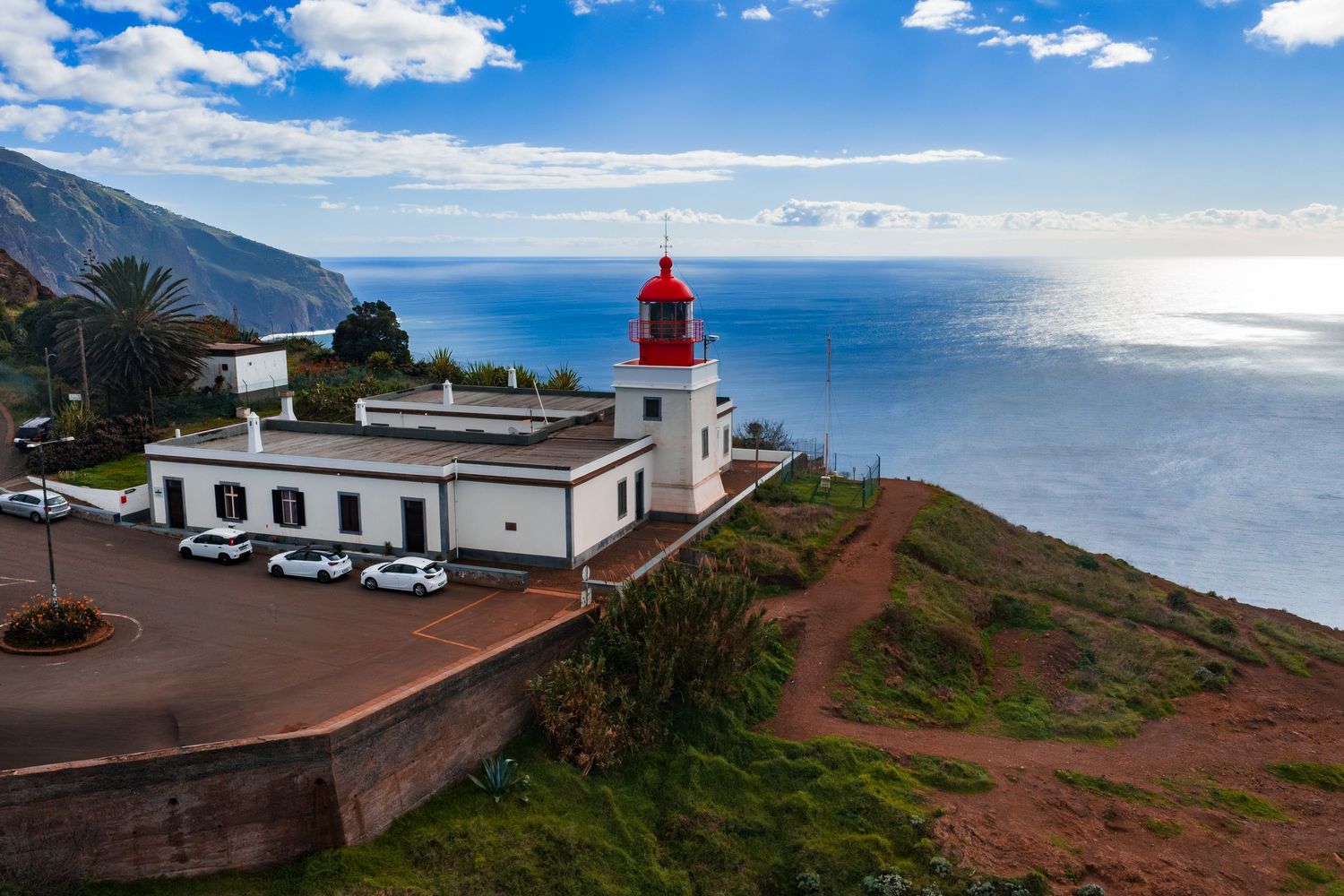 Lighthouse perched on a coastal cliff overlooking the blue Atlantic Ocean in La Palma, Canary Islands on a sunny day.