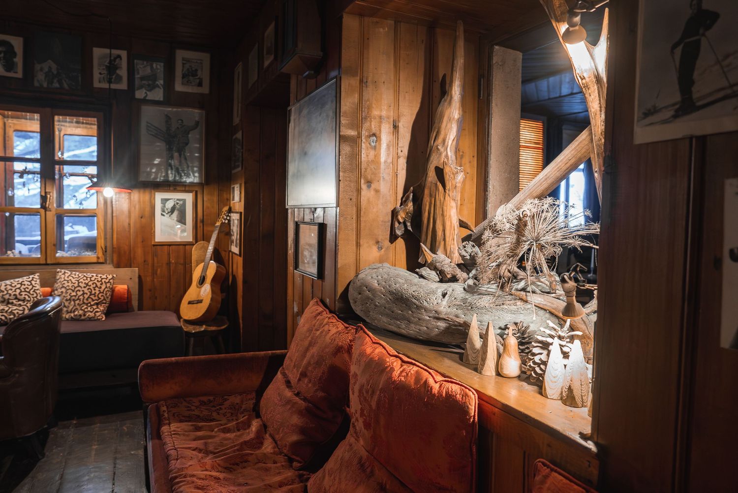 Cozy lodge interior featuring rustic decor, musical instruments, and natural lighting through windows.