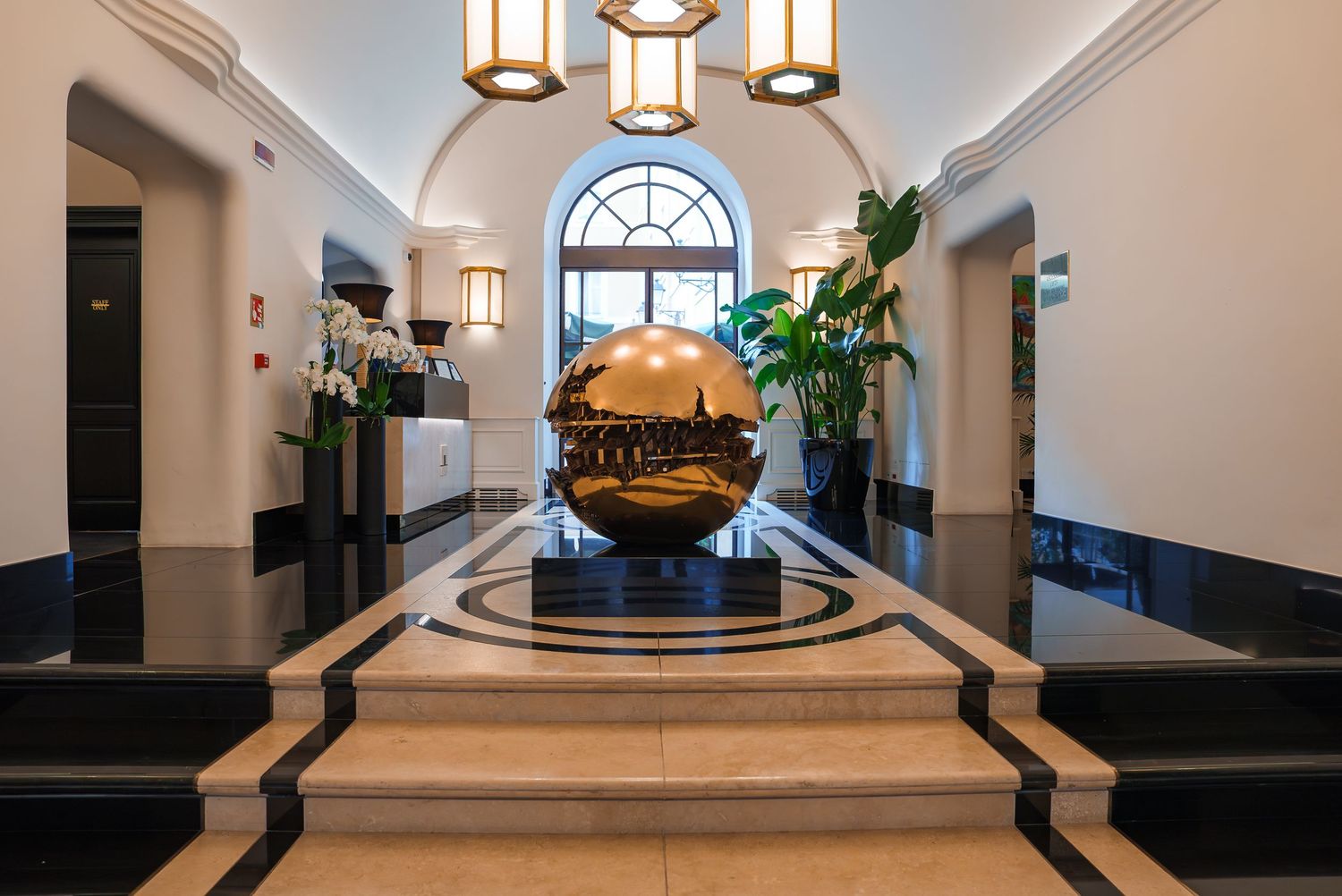 Elegant hotel lobby interior with arched windows and pendant lighting.