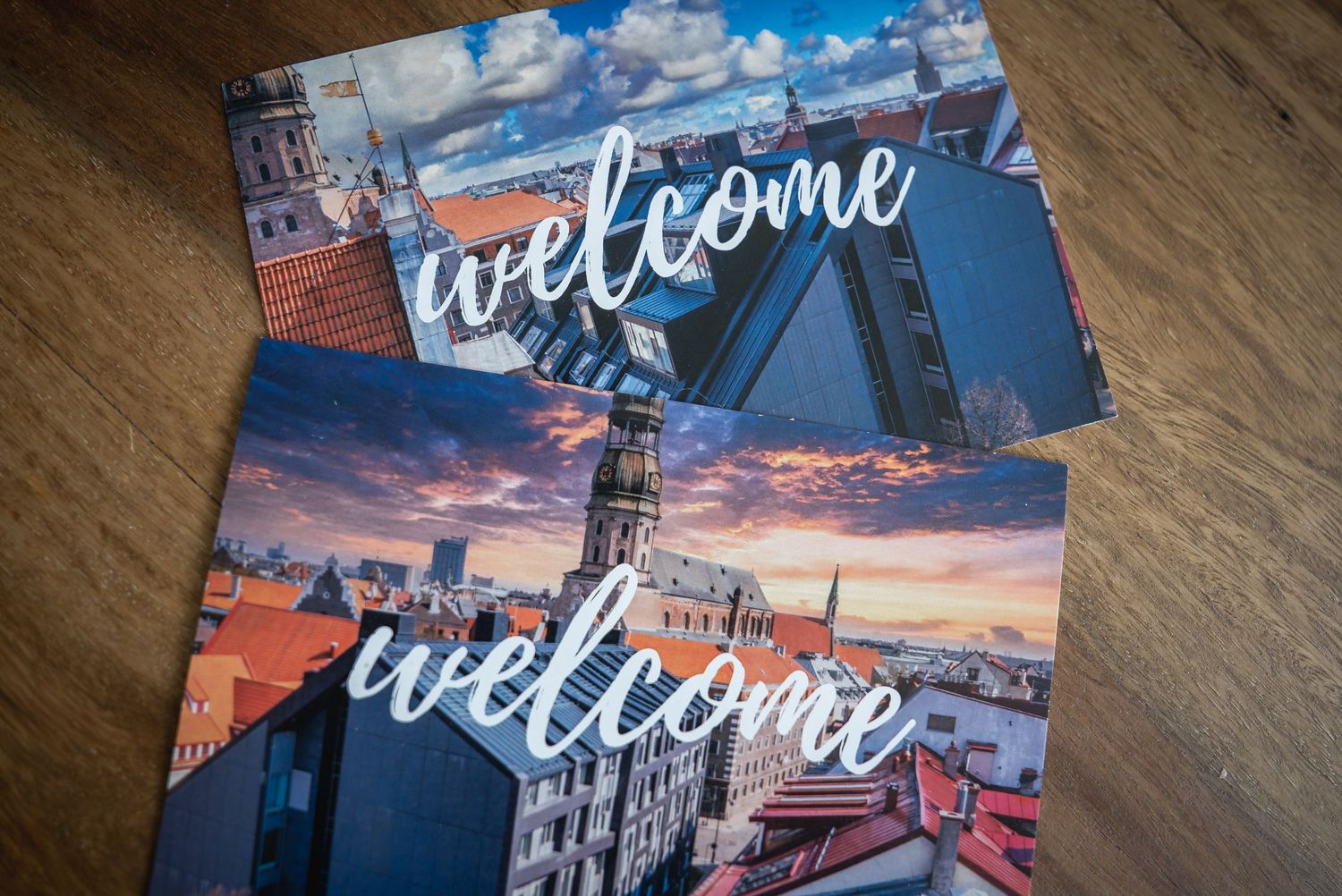 Stack of welcome cards featuring cityscape photography at sunset.