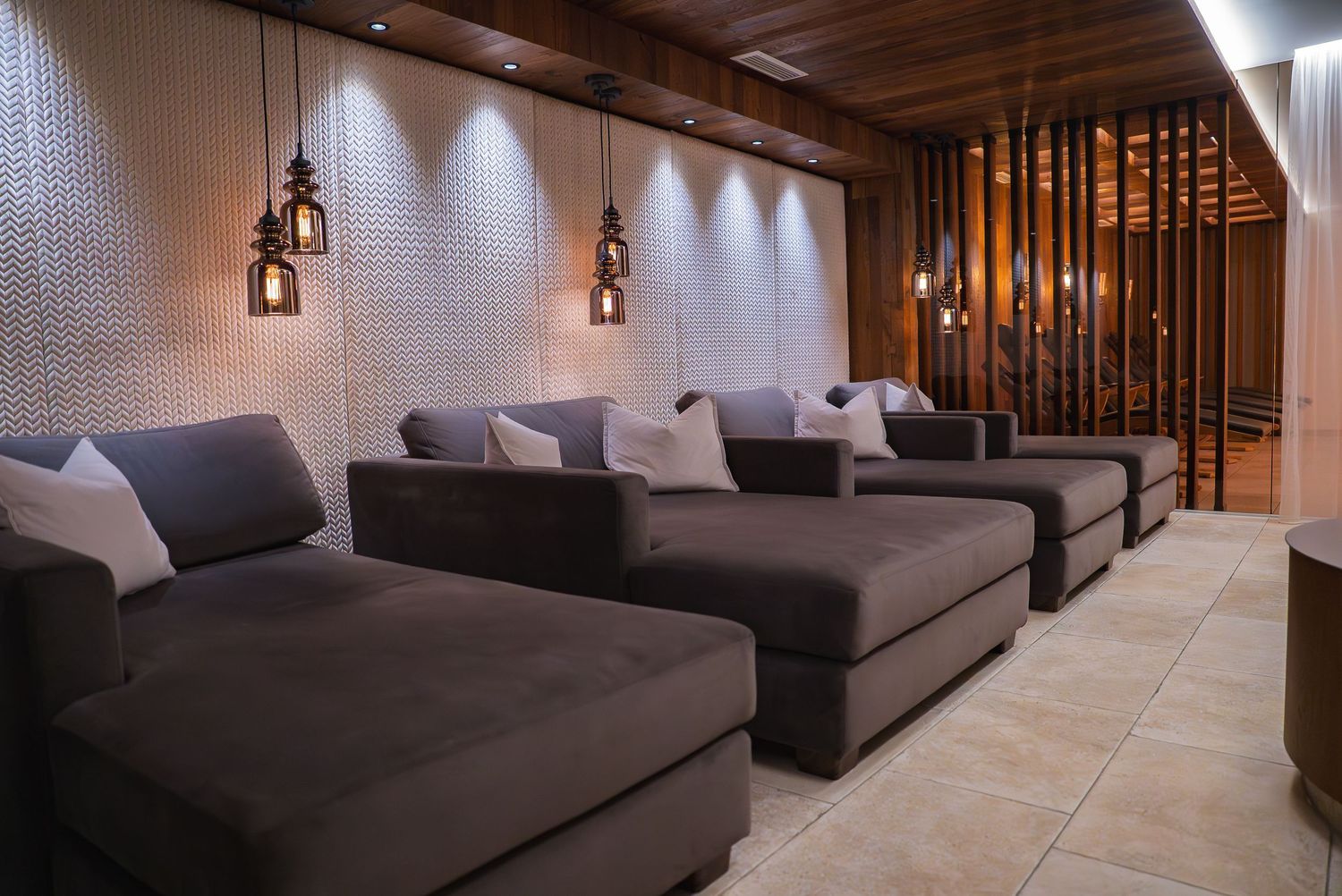 Modern lounge space with gray sectional sofas and contemporary lighting fixtures.