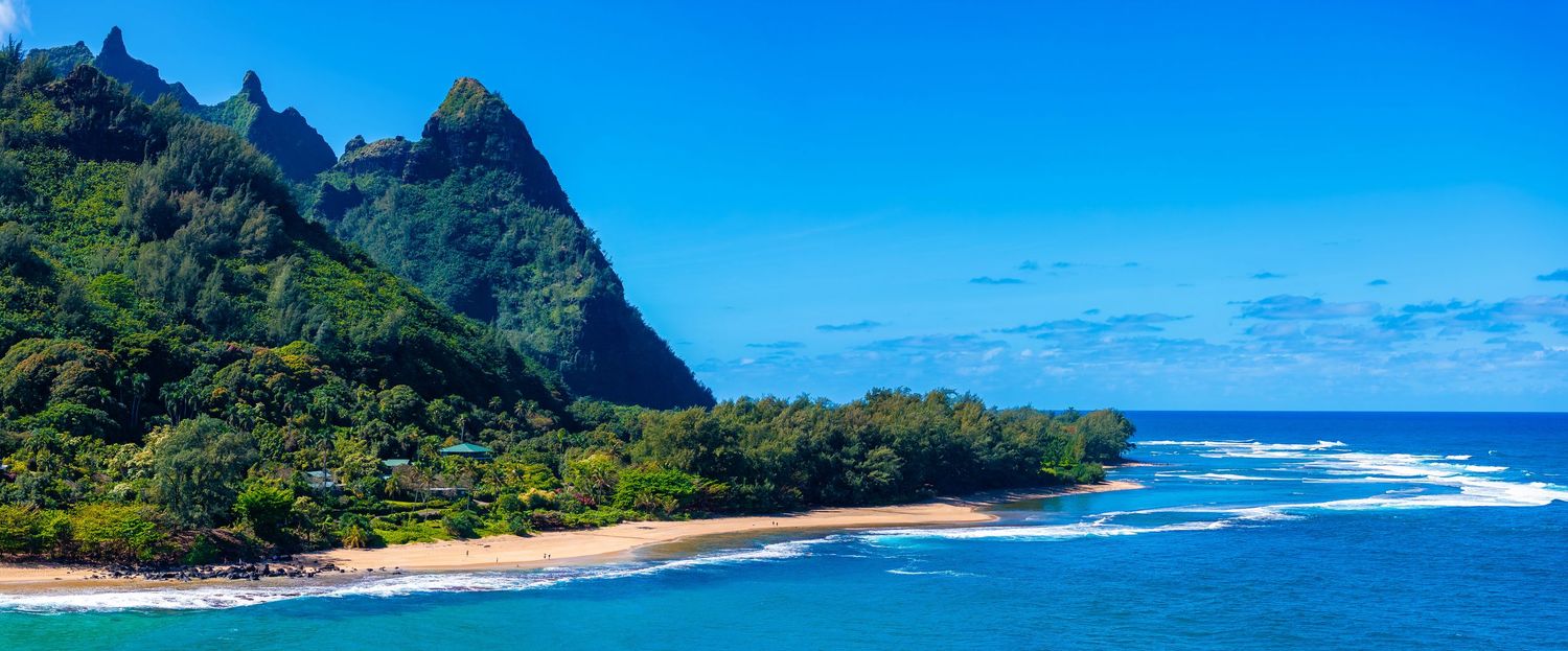 Tropical coastline with rugged mountains and crystal clear blue waters along Na Pali coast.
