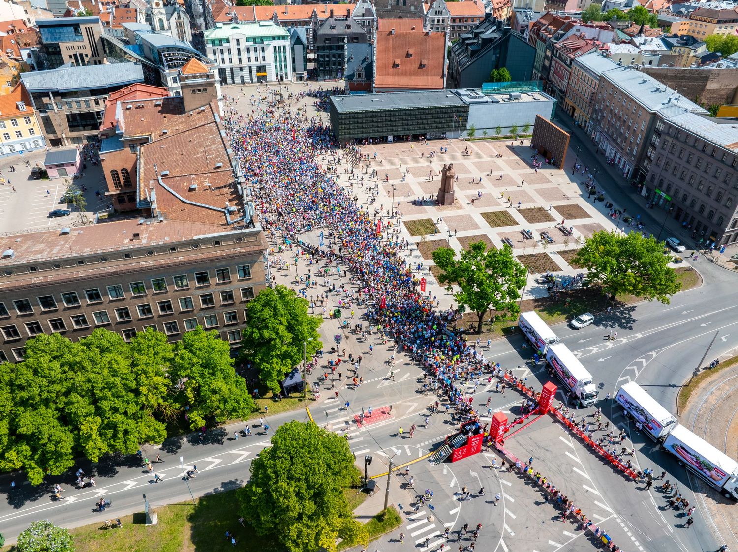Aerial view of a large public gathering with crowds filling city streets and squares.
