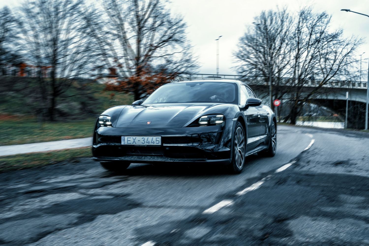 Sleek Porsche Taycan electric vehicle shown from multiple angles on a wet road at dusk.