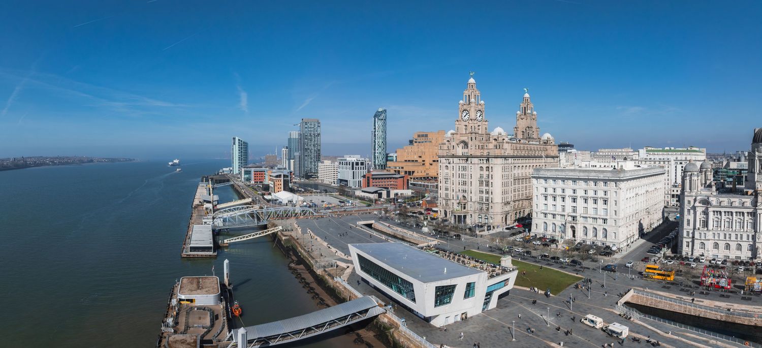 Liverpool waterfront panorama featuring the historic Three Graces buildings and modern skyscrapers.