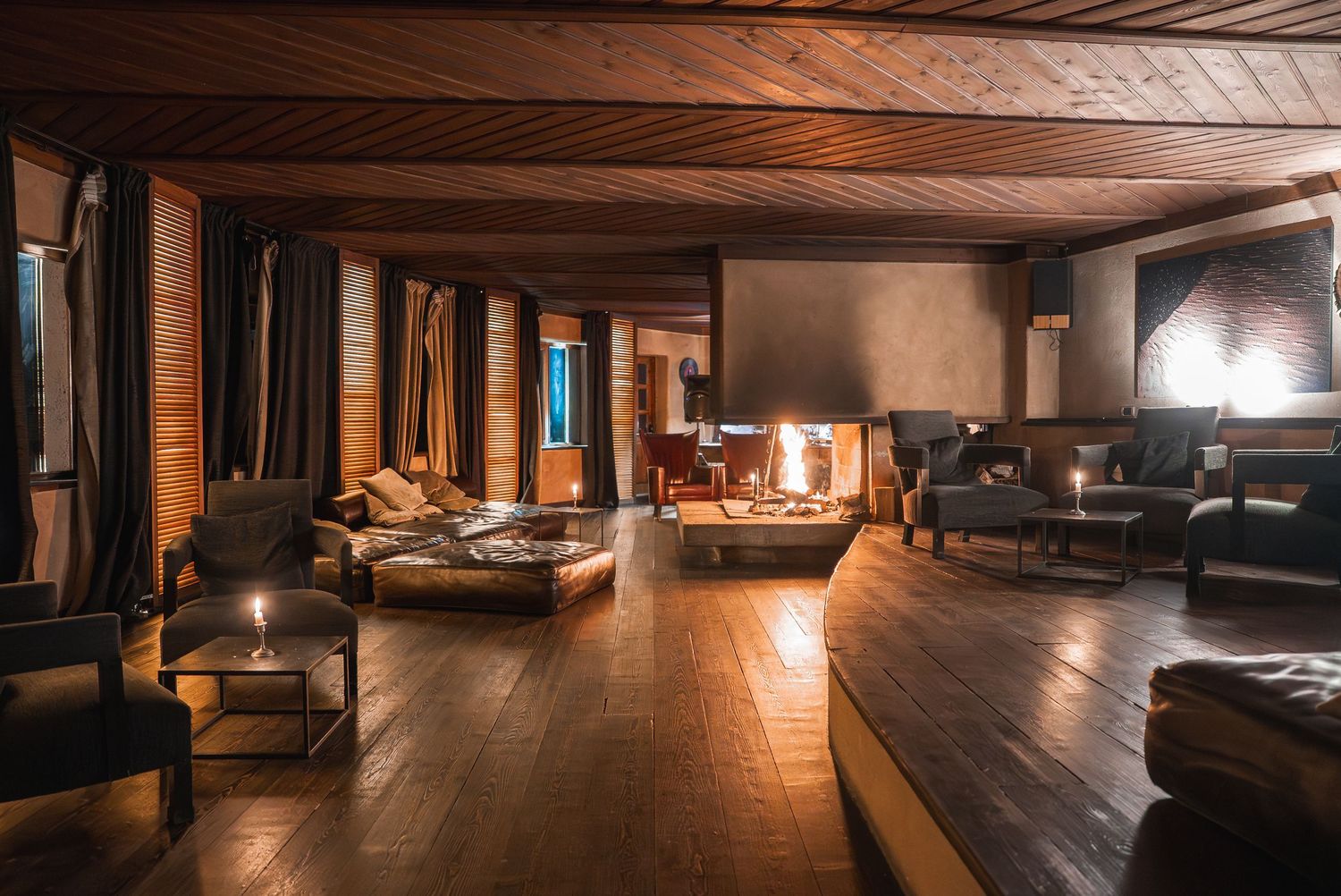 Long wooden hallway with dramatic lighting and rustic ceiling beams in a mountain lodge.