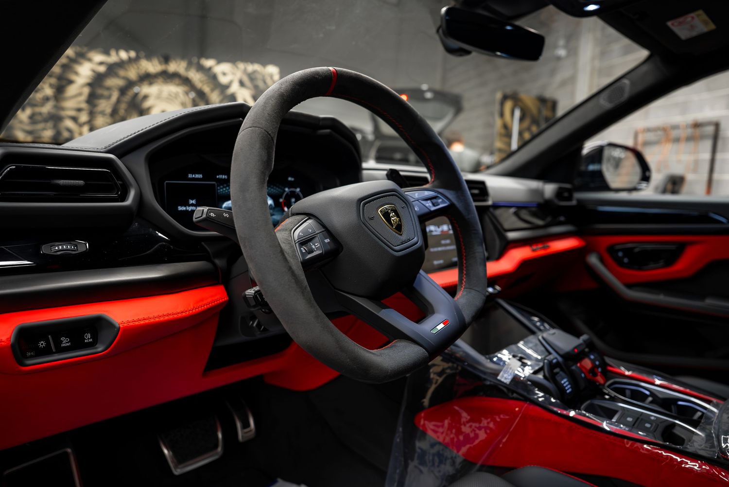 Modern sports car interior featuring red and black leather with carbon fiber trim details.
