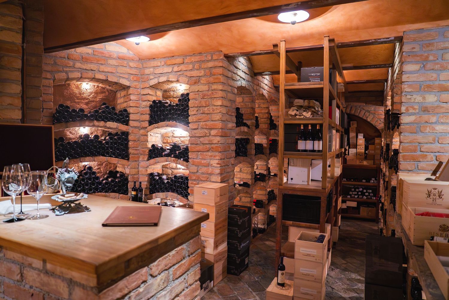 Rustic wine cellar with exposed brick walls and wooden storage features.