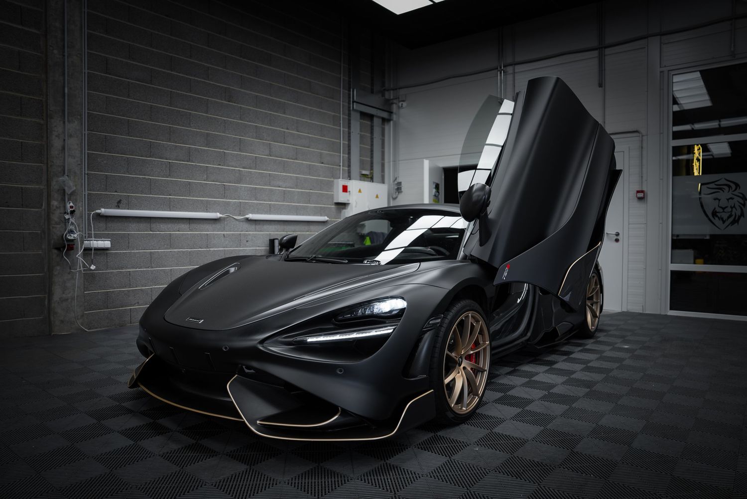 Side profile view of a luxury sports car with scissor doors in a dimly lit indoor space.