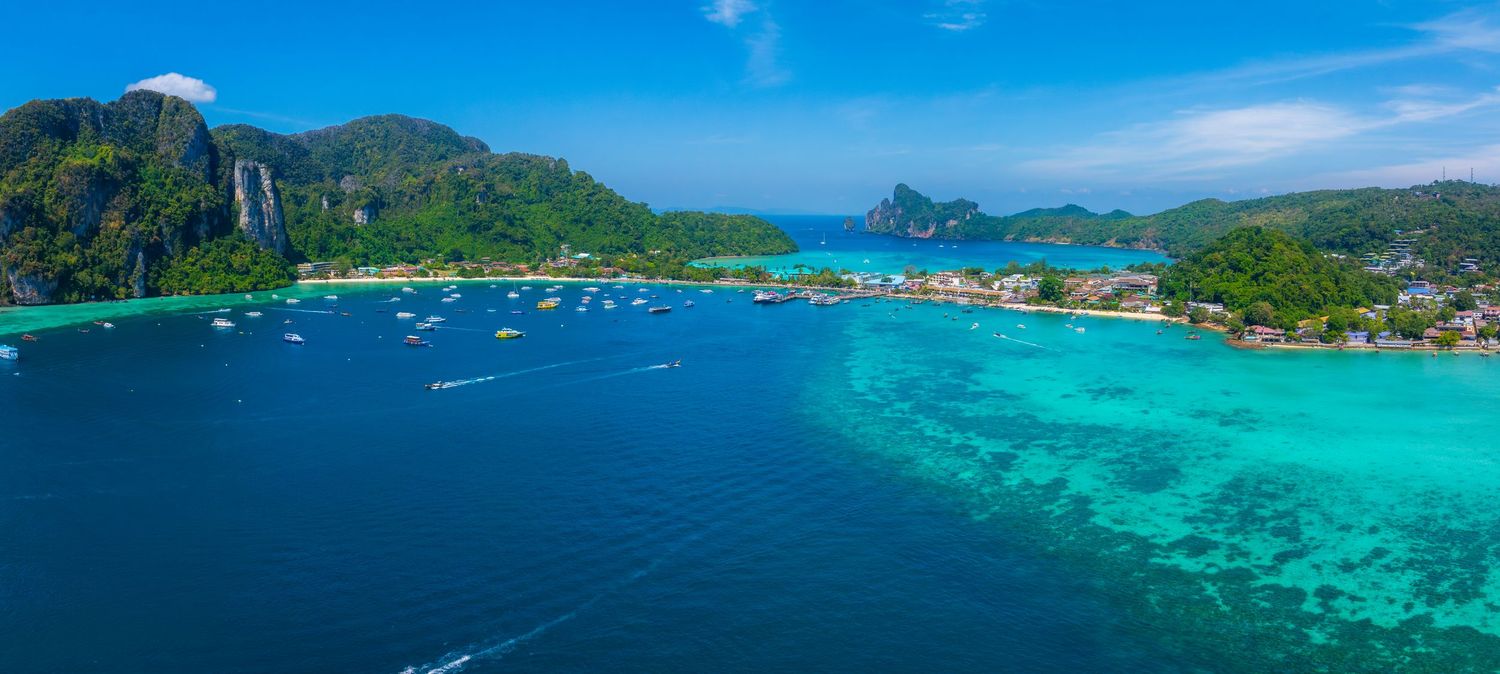 Stunning panoramic view of tropical islands and crystal clear turquoise waters under bright blue sky.
