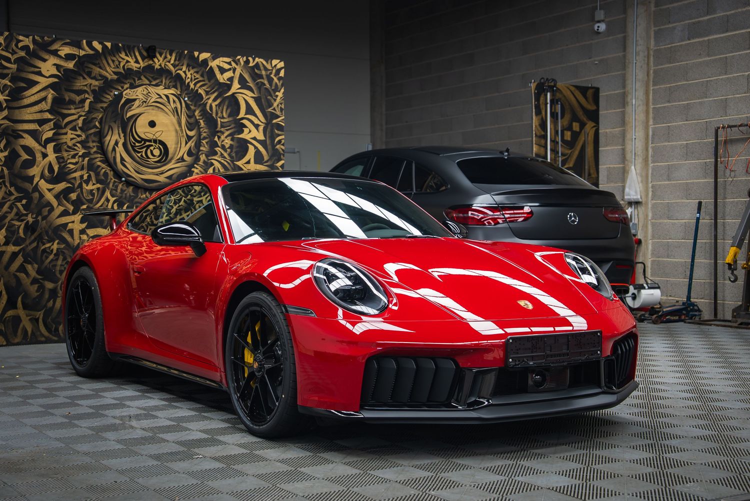 Collection of red luxury supercars displayed in an elegant showroom with artistic wall designs.