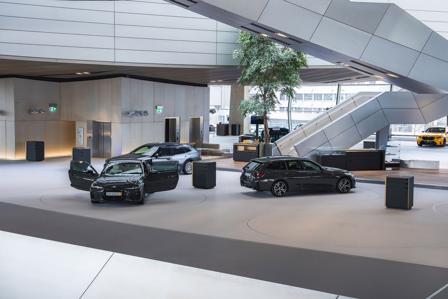 Sleek modern parking garage entrance with luxury vehicles and angular architecture.