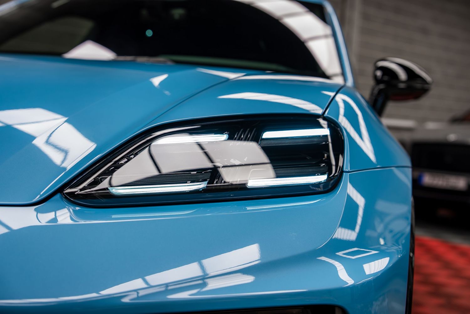 Side profile shots of a light blue luxury sports car showing aerodynamic design details.