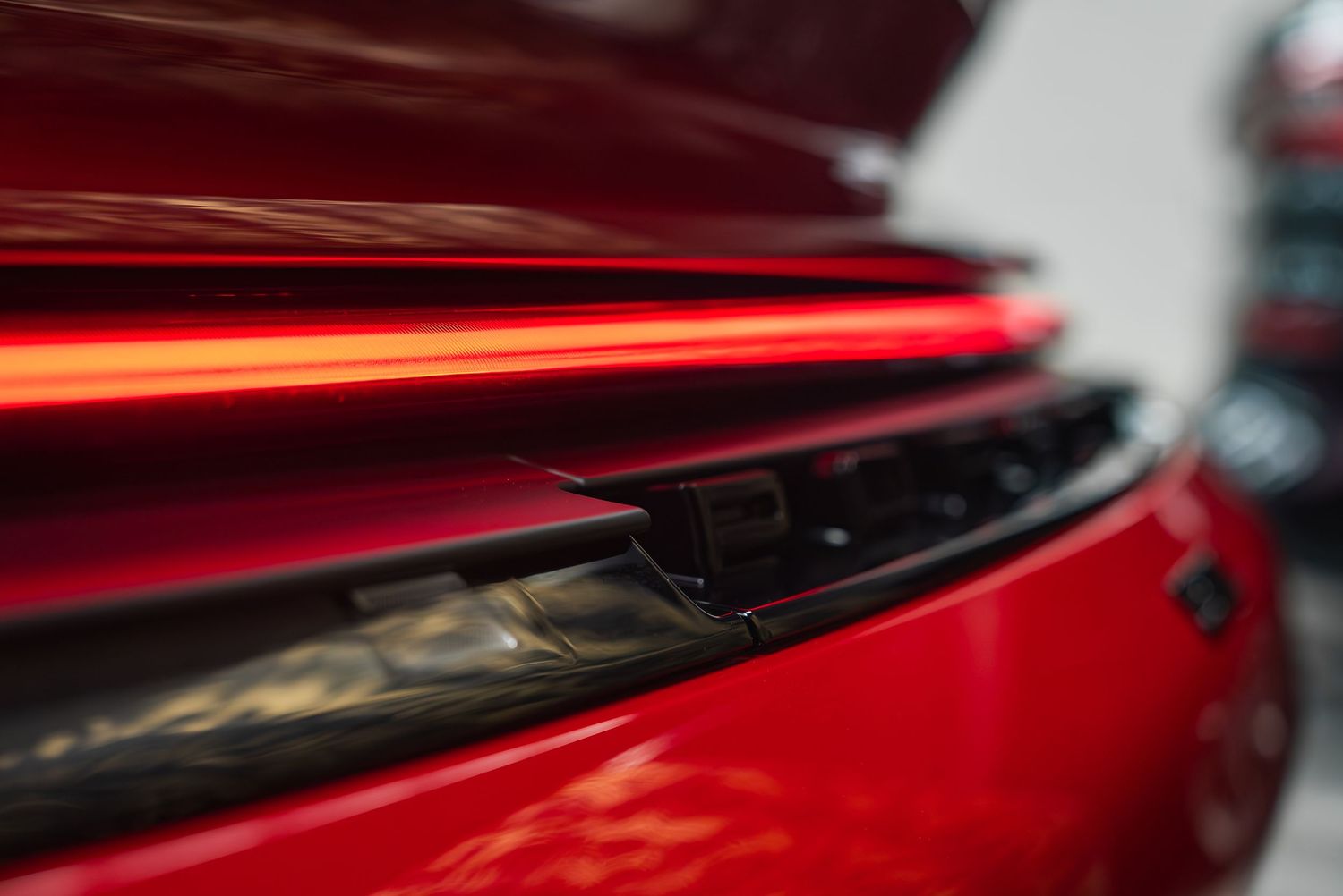 Close-up details of red sports car exterior highlighting sleek design elements.