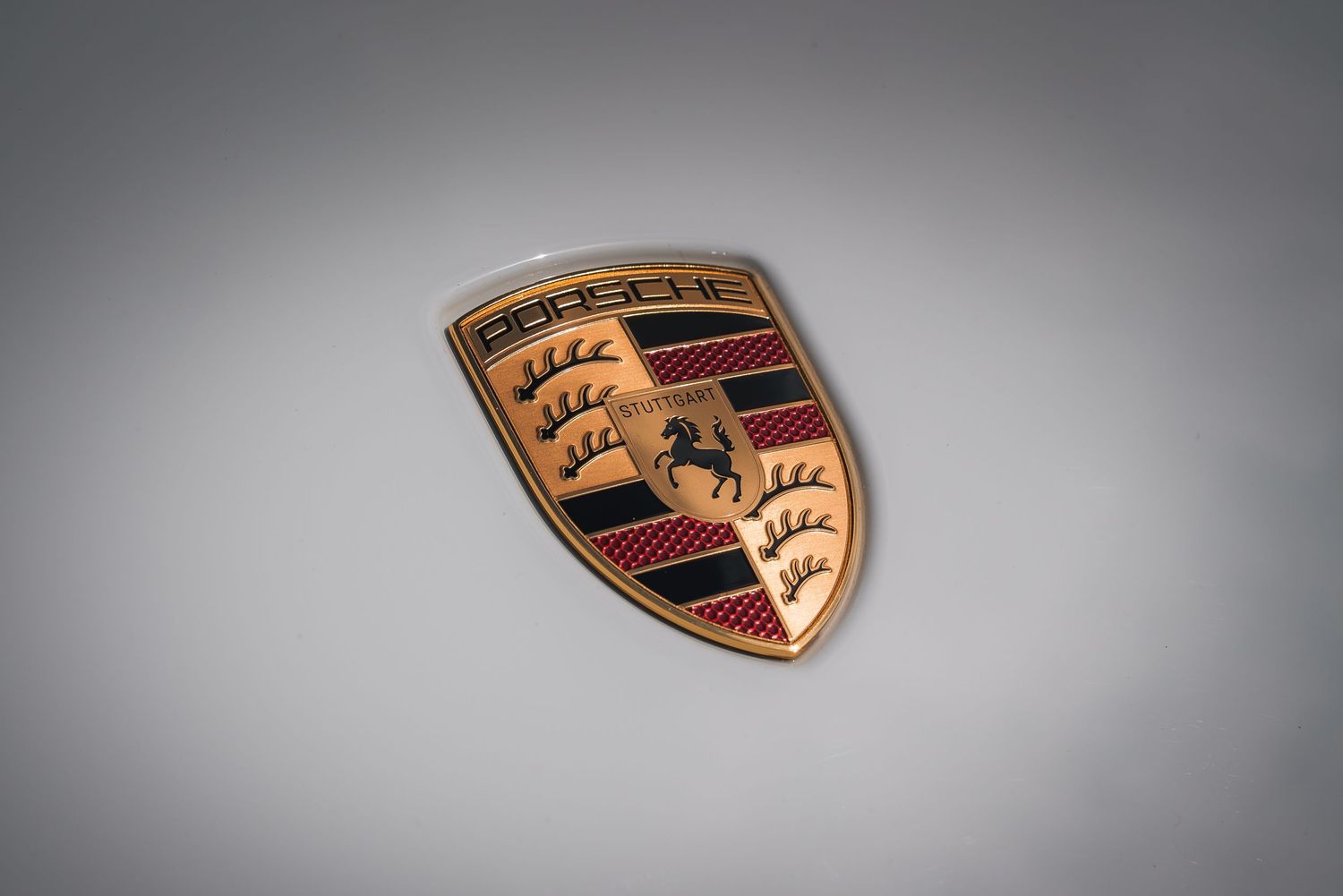 Series of Porsche emblems displayed against a gradient gray background.