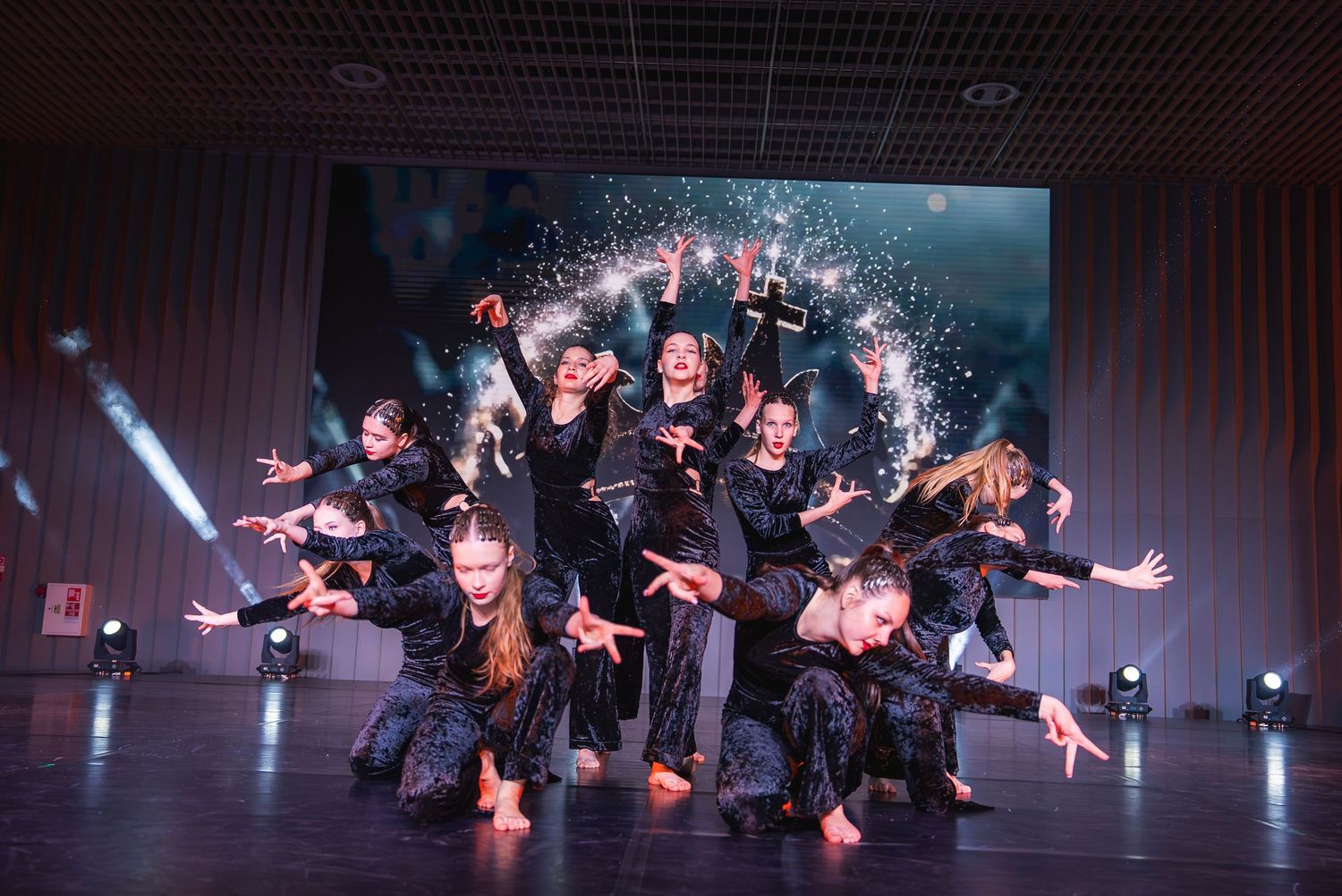 Contemporary dancers performing dramatic floor choreography under theatrical lighting.