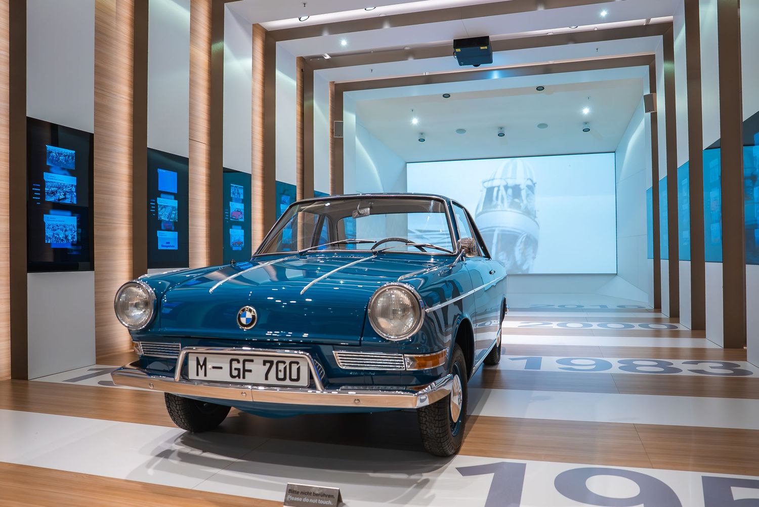 Sleek vintage BMW cars showcased in a modern museum gallery space.