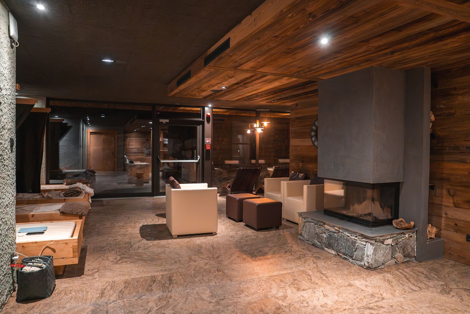 Rustic spa lounge area with wooden ceiling beams and ambient lighting.