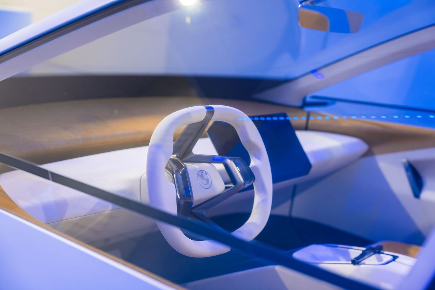 Modern BMW concept car interior with futuristic blue lighting and digital displays.