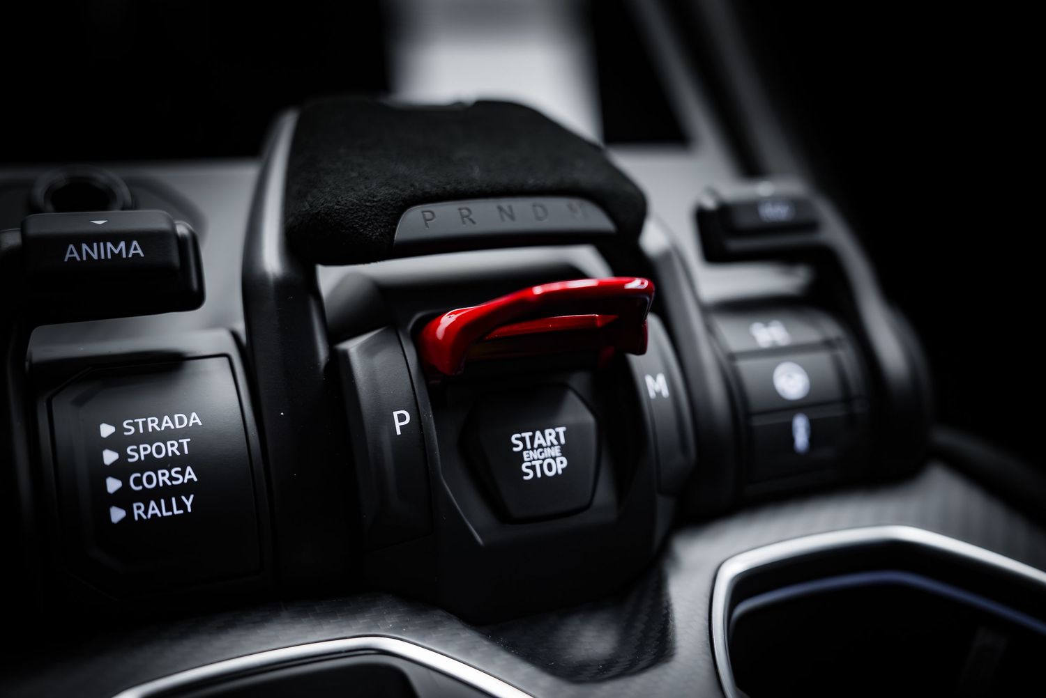 Close-up detail of car interior controls and buttons in black with subtle illumination.